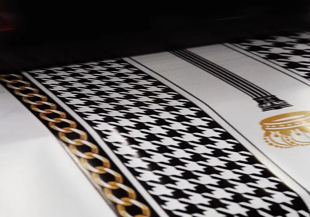 Baosiwei eco solvent hybrid printer printing houndstooth and gold chain pattern tablecloth fabric — demonstrating complex design precision on 700mm belt platform